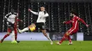 Pemain Fulham Antonee Robinson mencoba memblokir tembakan dari pemain Liverpool Mohamed Salah (kanan) pada pertandingan Liga Premier Inggris di Stadion Craven Cottage, London, Minggu (13/12/2020). Liverpool dan Fulham bermain imbang 1-1. (Neil Hall/Pool via AP)