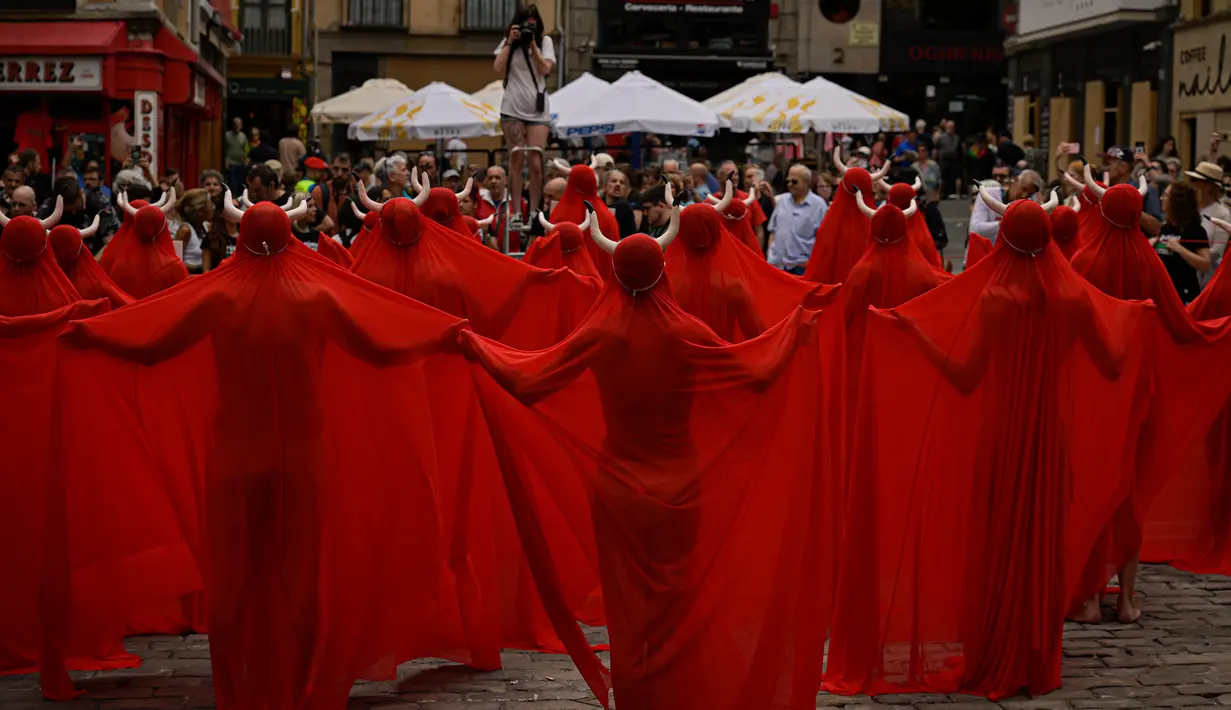 Sejumlah orang yang menutup diri dengan kain warna merah menarik perhatian warga saat memprotes kekejaman terhadap hewan sebelum dimulainya Festival San Fermin. (AP Photo/Alvaro Barrientos)