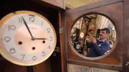 Hussein Mahmud (45) mengecek kerusakan jam antik di gudangnya di daerah Maidan Baghdad (20/2). Mahmud  mendapatkan jam-jam kuno dari orang Jerman dan Amerika, setelah memperbaiki, dia menjual jam ini ke penggemar barang antik. (AFP Photo/Ahmad Al-Rubaye)