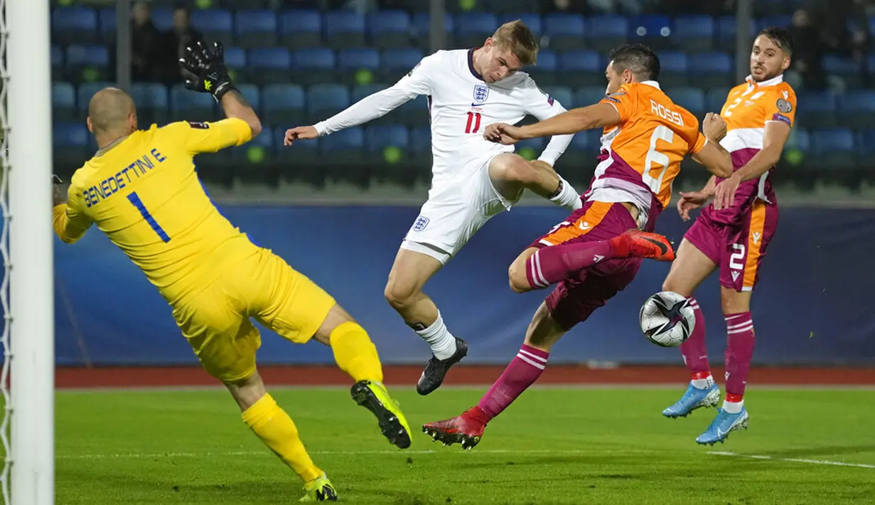 Pemain Inggris Emile Smith Rowe (tengah) berebut bola dengan kiper San Marino Elia Benedettini dan Dante Rossi pada pertandingan sepak bola Kualifikasi Grup I Piala Dunia 2022 di Stadion Olimpiade, Serravalle, San Marino, 15 November 2021. Inggris menang 10-0. (AP Photo/Antonio Calanni)