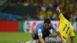 Pemain belakang Uruguay, Diego Lugano (kiri) terjatuh akibat diganjal gelandang Kolombia, Juan Cuadrado, saat berlaga di 16 besar Piala Dunia 2014 di Stadion Maracana, Rio de Janeiro, (29/6/2014). (REUTERS/Kai Pfaffenbach) 