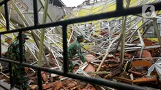 Petugas Babinsa TNI AD membersihkan reruntuhan atap yang ambruk akibat gempa di salah satu ruang kelas di MAN 2 Malang, Turen, Kabupaten Malang, Minggu (11/4/2021). Gempa bermagnitudo 6,1 yang terjadi pada Sabtu (10/9) siang menyebabkan kerusakan berat di MAN 2 Malang. (merdeka.com/Nanda F. Ibrahim)