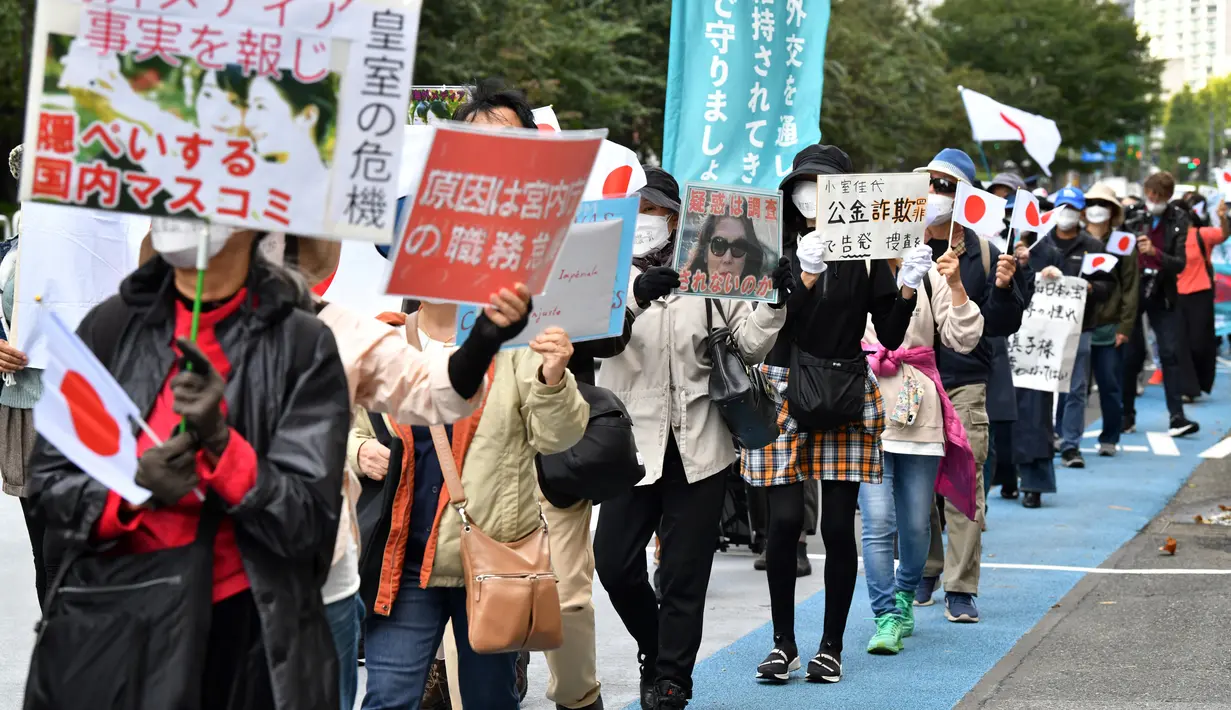 Orang-orang mengambil bagian dalam pawai untuk memprotes pernikahan antara Putri Jepang Mako dan Kei Komuro di Tokyo (26/10/2021). Putri Mako secara resmi kehilangan status kerajaannya setelah menikahi kekasih semasa kuliah, Kei Komuro pada Selasa (26/10). (AFP/Kazuhiro Nogi)
