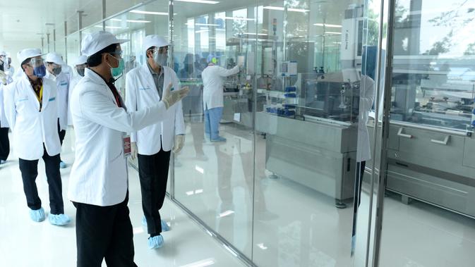 Presiden Joko Widodo atau Jokowi (kanan) meninjau fasilitas produksi dan pengemasan di PT Bio Farma, Bandung, Jawa Barat Selasa (11/8/2020). Jokowi menggunakan pakaian lengkap penelitian untuk melihat Laboratorium Bio Farma. (Foto: Biro Pers Kepresidenan)