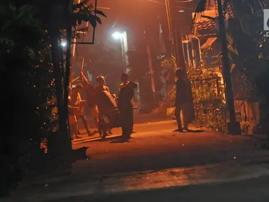 Sejumlah anak menggunakan alat musik dari tong sampah untuk membangunkan warga saat sahur di kawasan Mekarsari, Depok, Jawa Barat, Rabu (8/5/2019). Dengan alat seadanya, anak-anak penuh semangat berkeliling membangunkan warga sekitar untuk sahur. (Liputan6.com/Herman Zakharia)