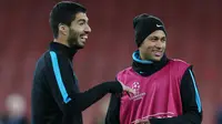 Penyerang Barcelona, Luis Suarez (kiri) dan Neymar berbincang saat sesi latihan di Emirates Stadium, Inggris, (23/2). Barcelona akan bertanding melawan Arsenal di leg pertama 16 besar Liga Champions. (Reuters/Matius Childs)