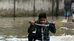 Anak-anak bermain di tengah banjir setelah hujan lebat mengguyur Lahore, Punjab, Pakistan, 20 Agustus 2020. Sebanyak 18 orang tewas dan banyak lainnya terluka akibat hujan lebat di Punjab. (Xinhua/Sajjad)