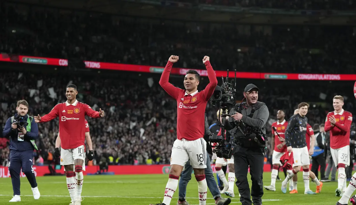 Gelandang Manchester United, Casemiro (tengah) merayakandengan rekan setimnya setelah menjadi juara Carabao Cup 2022/2023 mengalahkan Newcastle United pada laga final di Stadion Wembley di London, Senin dini hari WIB (27/2/2023). Atas penampilan gemilangnya, Casemiro terpilih sebagai pemain terbaik dalam laga tersebut. (AP Photo/Alastair Grant)