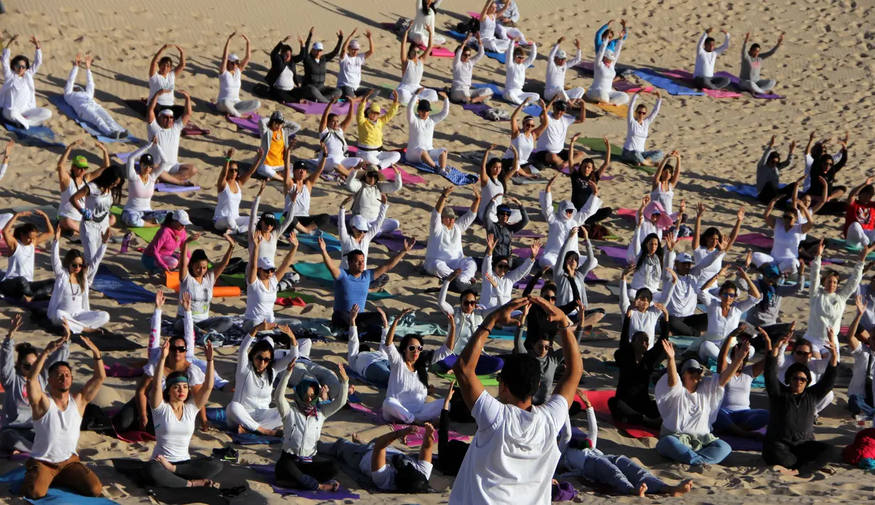 Peserta mengikuti kelas yoga yang digelar di gurun Samalayuca, negara bagian Chihuahua, Meksiko, 28 April 2018. Latihan di pasir gurun yang panas karena terik matahari menjadi ini tantangan tersendiri bagi para pencinta yoga. (AFP PHOTO / HERIKA MARTINEZ)