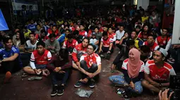 Sejumlah supporter klub Arsenal duduk bersama saat mengikuti acara Nonton Bola Seru Arsenal vs Chelsea di Andik Futsal, Depok, Jawa Barat, Minggu (26/4/2015). Kedua tim bermain imbang 0-0. (Liputan6.com/Helmi Fithriansyah)