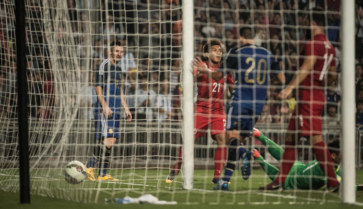 Striker Timnas Argentina, Lionel Messi (kiri) menyaksikan gawang Timnas Hong Kong jebol pada laga persahabatan internasional di Hong Kong Stadium, Hong Kong (14/10/2014). (AFP/Anthony Wallace)
