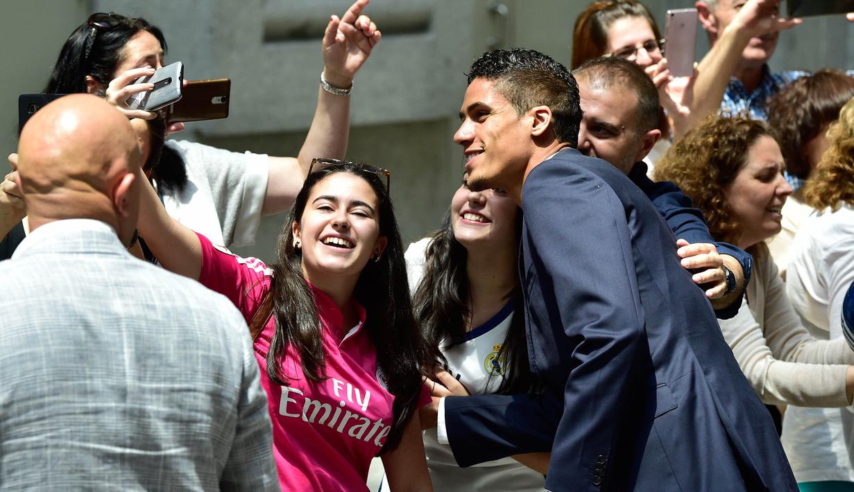 Bek Real Madrid, Raphael Varane berfoto bersama fans usai Madrid meraih gelar juara La Liga 2016-2017 di Madrid Town hall, Plaza Cibeles,  Madrid, (22/5/2017).  (AFP/Gerard Julien) 