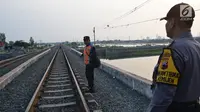 Petugas gabungan dari Polsuska dan Babinkamtibmas Kemijen Semarang memeriksa rel kereta api di Jalur Kemijen, Minggu (3/6). Pemeriksaan rel dilakukan untuk pengamanan jalur kereta api jelang arus mudik lebaran 2018. (Liputan6.com/Gholib)