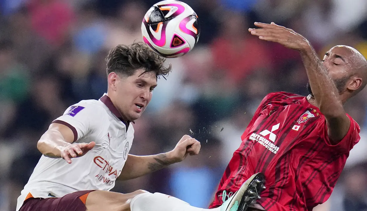 Bek Manchester City, John Stones (kiri) berebut bola dengan striker Urawa Red Diamonds, Jose Kante pada laga semifinal Piala Dunia Klub 2023 di King Abdullah Sports City Stadium, Jeddah, Arab Saudi, Rabu (20/12/2023) dini hari WIB. (AP Photo/Manu Fernandez)