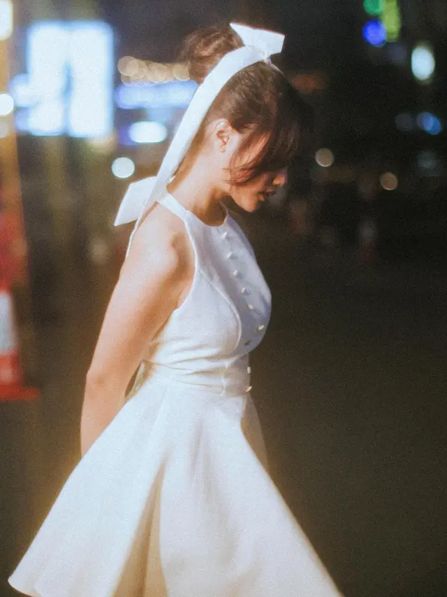 6 Pesona Estetik Fuji Utami Pakai Gaun Mini Putih di Pinggir Trotoar dengan Gaya Vintage