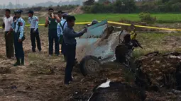 Tentara Myanmar menjaga reruntuhan jet tempur yang jatuh di area persawahan desa Kyunkone, berjarak satu jam dari ibu kota Naypyidaw, Selasa (3/4). Pihak kepolisian mengatakan pesawat yang jatuh merupakan tipe F-7 dengan kemudi tunggal. (AFP Photo)