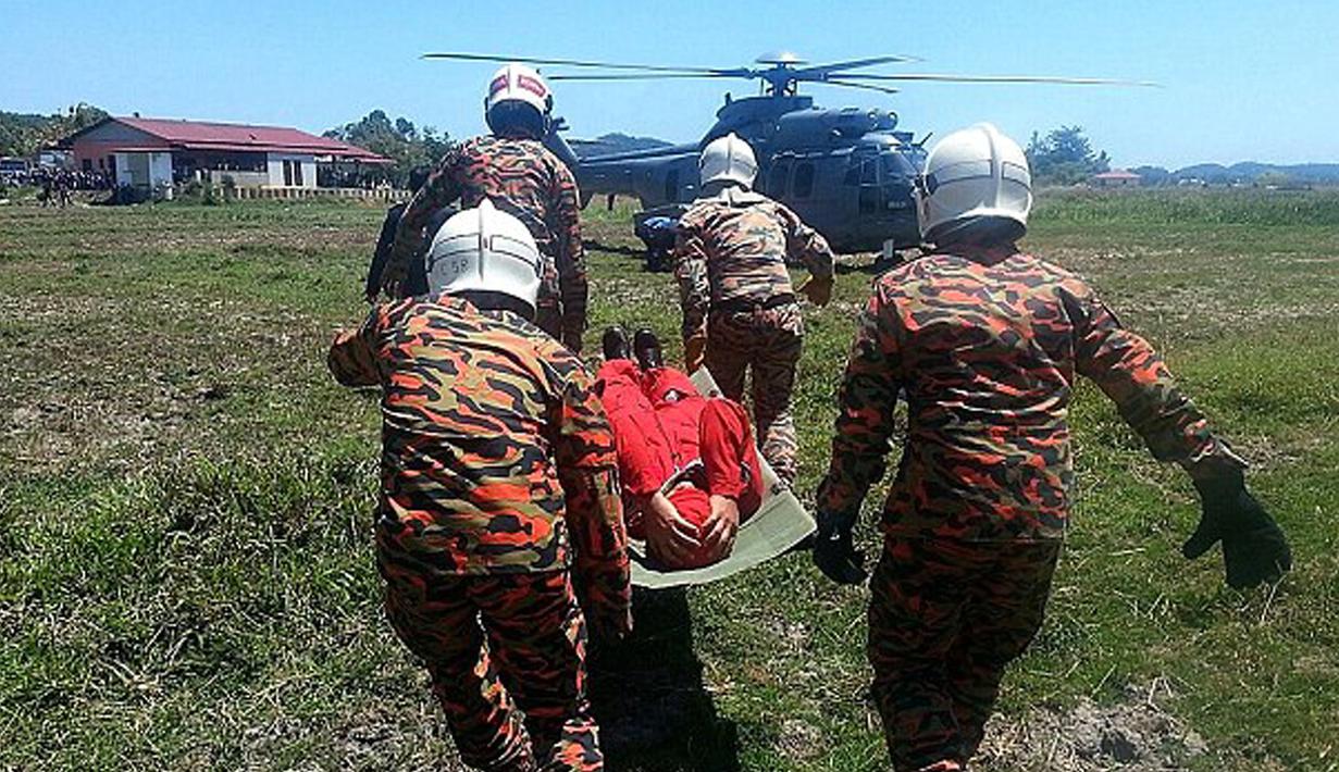 Personel AU Malaysia terlihat membawa salah satu awak pesawat tim aerobatik TNI AU Jupiter menggunakan helikopter menuju rumah sakit, Minggu (14/3/2015). (Dailymail)