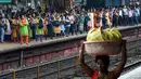 Penumpang menunggu kereta lokal tiba di Mumbai, India, Kamis (8/9/2022). Untuk kereta kelas ekonomi di India biasanya menggunakan lokomotif diesel. (Indranil MUKHERJEE/AFP)