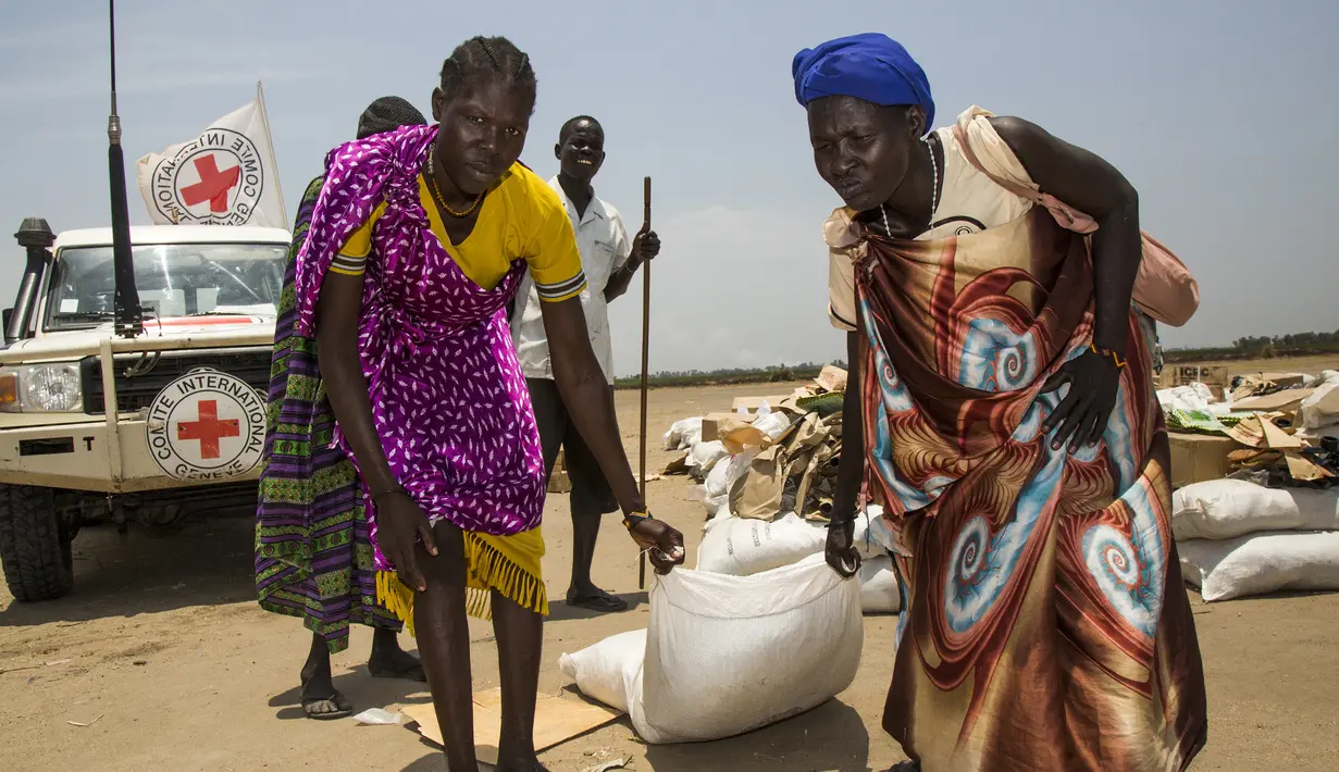 Warga membawa bahan makanan yang didistribusikan oleh ICRC di daerah yang dikuasai oposisi di Thonyor, Sudan, Selasa (11/4). UNHCR mengatakan Sudan Selatan, Nigeria, Somalia dan Yaman kini berada di ambang kelaparan. (AFP PHOTO / Albert Gonzalez Farran)