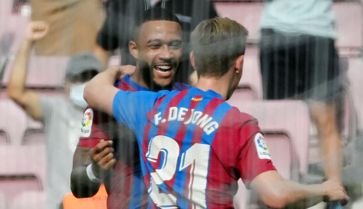Memphis Depay dan Frenkie de Jong - Barisan lini serang Barcelona kini kental dengan aura Timnas Belanda. Depay dan De Jong saat ini tengah berjuang bersama membawa kembali masa kejayaan Barcelona. (AFP/Lluis Gene)