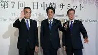 Perdana Menteri China Li Keqiang, Perdana Menteri Jepang Shinzo Abe dan Presiden Korea Selatan Moon Jae-in menyapa awak media usai melakukan pertemuan tingga negara di Tokyo, Jepang (9/5). (AP Photo/Eugene Hoshiko, Pool)