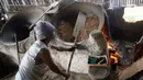 Pekerja mengolah kacang dengan media pasir di salah satu industri rumahan pembuatan kacang sangrai di Kawasan Keranggan, Tangerang Selatan, Selasa (11/8/2020). Kacang sangrai yang dipasarkan seharga Rp10.000 per kg itu mulai mengalami kenaikan pesanan dibanding bulan lalu. (merdeka.com/Dwi Narwoko)
