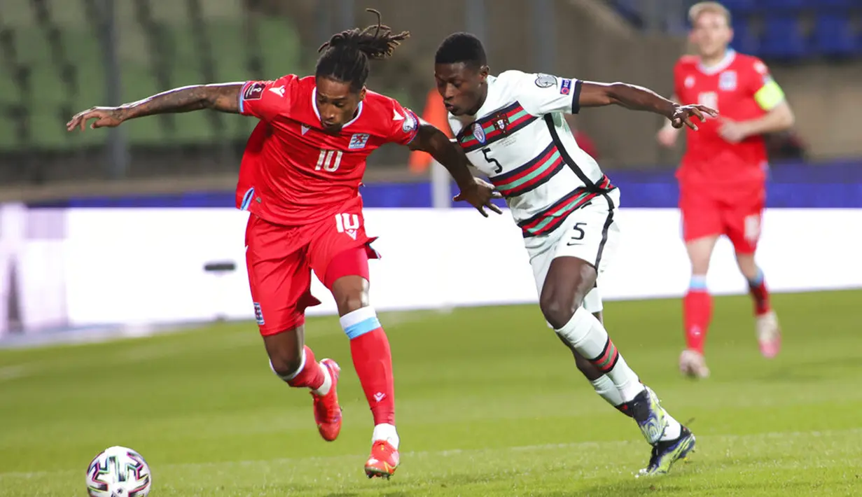 Pemain Luksemburg Gerson Rodrigues dikejar oleh pemain Portugal Nuno Mendes pada pertandingan Grup A kualifikasi Piala Dunia 2022 di Stadion Josy Barthel, Luksemburg, Selasa (30/3/2021). Portugal menang 3-1. (AP Photo/Olivier Matthys)