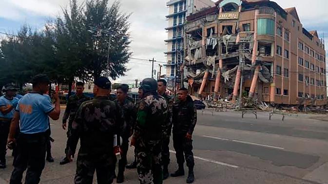 Polisi mengamankan area dekat Hotel Eva yang rusak usai gempa bumi kuat di Kidapawan, provinsi Cotabato utara, Kamis (31/10/2019). Gempa bumi kembali mengguncang Filipina selatan, kali ini bermagnitudo 6,5 dan merupakan gempa kuat ketiga yang berpotensi menimbulkan kerusakan. (AP/Williamor Magbanua)