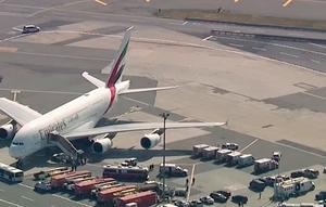 Petugas tanggap darurat berkumpul di luar pesawat setelah sekitar 100 penumpang Emirates Airline dilaporkan sakit di Bandara Kennedy New York, Rabu (5/9). Pesawat dari Dubai ke New York itu dikarantina dan dipantau polisi kontra-terorisme. (WABC 7 via AP)