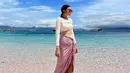 Foto luar biasa lainnya, Tiffany berada di pantai yang indah mengenakan outfit beach-wear. Ia mengenakan swimsuit putih yang memiliki potongan edgy, dipadu dengan kain ungu muda yang dililitkannya sebagai bawahan, diikatkan di pinggangnya. Foto: Instagram.