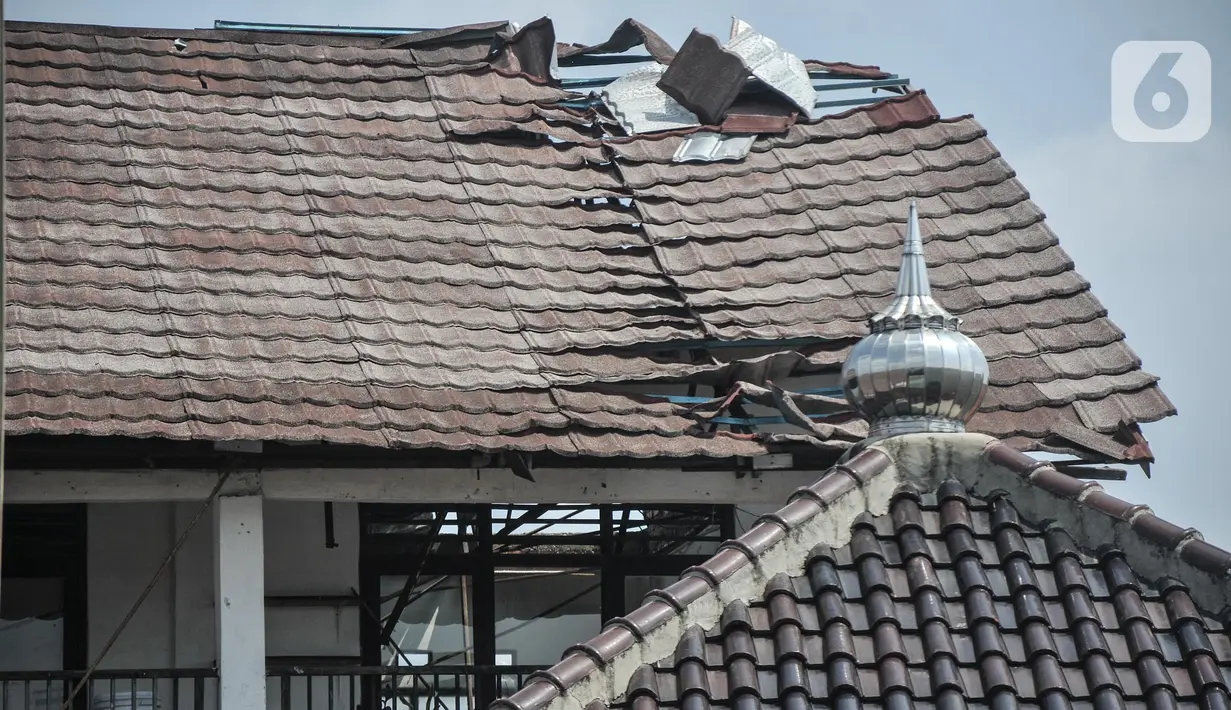 Tampak dari luar kondisi atap salah satu ruang kelas yang rusak akibat terjangan angin kencang di SDN Pancoranmas 3, Depok, Jawa Barat, Minggu (24/7/2022). Seperti diketahui, Pemkot Depok telah menganggarkan Rp300 juta untuk perbaikan ruang kelas SDN Pancoranmas 3 Depok melalui pengajuan dana BTT (belanja tidak terduga) tahun 2022. (merdeka.com/Iqbal S. Nugroho)