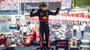 Pebalap Red Bull, Max Verstappen menaiki kendarannya usai memenangkan F1 GP Austria di Red Bull Ring, Spielberg, Minggu (30/6/2019). Max Verstappen menggeser Sebastian Vettel dari peringkat ketiga klasemen F1. (ANDREJ ISAKOVIC/AFP)