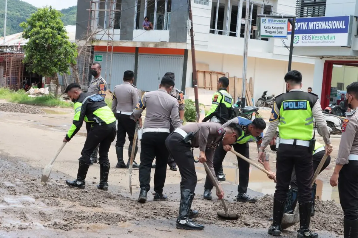 Satuan Lalu Lintas Polres Manggarai Barat bersama warga memperbaiki jalan yang rusak. (Foto Istimewah)