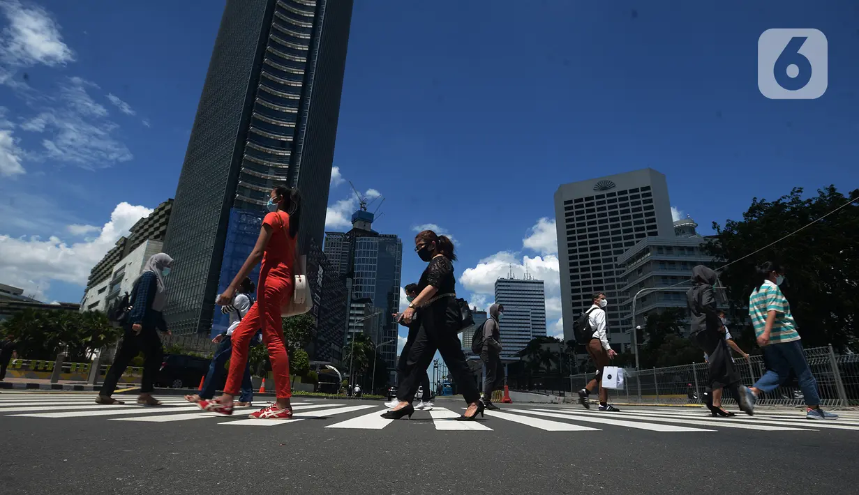 Pejalan kaki melintasi pelican crossing di Jakarta 1/12/2020). Kota Jakarta dengan langit biru menambah keindahan hutan beton. BMKG bahwa kualitas udara Jakarta jadi baik dalam dua minggu ini, Jakarta mengalami hujan dengan intensitas tinggi disertai angin kencang. (merdeka.com/Imam Buhori)