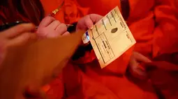 Para tamu mengisi formulir yang mengungkapkan kejahatan mereka saat mengunjungi bar koktail Alcotraz  di London , 11 Oktober 2018. Bar unik berkonsep penjara ini membuat pengunjung merasakan sensasi menjadi narapidana. (BEN STANSALL / AFP)