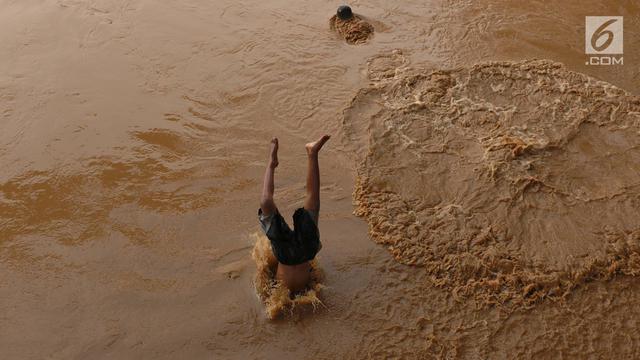Nekat, Anak-Anak Ini Berenang di Sungai Ciliwung yang Meluap