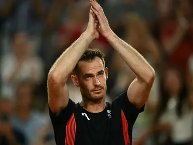 Petenis Inggris Andy Murray mengucapkan selamat tinggal setelah bermain dengan Daniel Evans melawan petenis Amerika Taylor Fritz dari AS dan Tommy Paul pada babak perempat final nomor ganda putra tenis Olimpiade Paris 2024 di Court Suzanne-Lenglen di Stadion Roland-Garros, Kamis (1/8/2024). (CARL DE SOUZA / AFP)