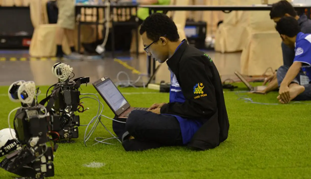 Seorang Programer robot mengecek robot yang akan bertanding di ajang RoboCup 2015 yang digelar di Hefei, provinsi Anhui, Cina (22/7/2015). Ajang RoboCup sebelumnya diselenggarakan di Brasil pada tahun lalu. (AFP/Stringer)