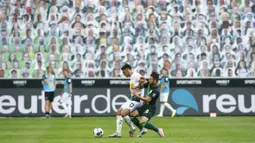 Penyerang Borussia Monchengladbach, Lars Stindl, berebut bola dengan gelandang Wolfsburg, Renato Steffen, pada laga lanjutan Bundesliga di Borussia Park Stadium, Rabu (17/6/2020) dini hari WIB. Monchengladbach menang telak 3-0 atas Wolfsburg.(AFP/Thilo Schmuelgen/pool)