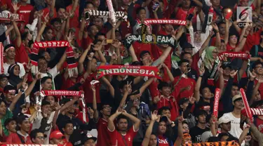 Suporter membentangkan syal saat merayakan kemenangan Timnas Indonesia U-19 atas Chinnese Taipei pada laga penyisihan Grup A Piala AFC U-19 2018 di Stadion GBK, Jakarta, Kamis (18/10). Indonesia unggul 3-1. (Liputan6.com/Helmi Fithriansyah)