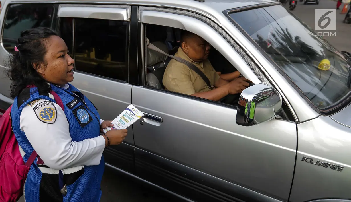 Petugas Dinas Perhubungan membagikan selebaran sosialisasi pemberlakuan sistem ganjil genap di pintu masuk Gardu Tol Cibubur 2, Jakarta, Senin (16/4). (Liputan6.com/Faizal Fanani)
