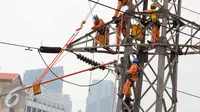 Petugas PLN memperbaiki Menara Sutet di Jalan Asia Afrika, Jakarta, Rabu (12/8/2015). Pekerjaan tersebut mengandung resiko besar karena jaringan listrik masih dipelihara tanpa dipadamkan. (Liputan6.com/Helmi Afandi)