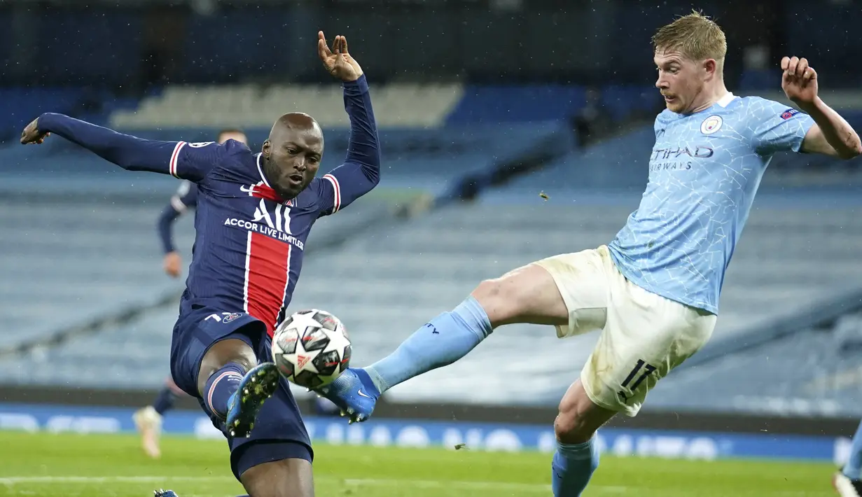 Bek PSG, Danilo berusaha merebut bola dari gelandang Manchester City, Kevin De Bruyne pada leg kedua semifinal Liga Champions di stadion Etihad, Rabu (5/5/2021). Dengan hasil ini, Manchester City melaju ke final Liga Champions untuk pertama kalinya dalam 66 tahun. (AP Photo/Dave Thompson)