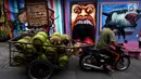 Pekerja membawa tabung gas di Kampung Warna-warni Jodipan dan Kampung Tridi (3D) di pinggir Sungai Brantas, Tumenggungan Ledok, Blimbing, Kota Malang, Jawa Timur (29/7). Kini kampung ini dikreasikan dengan penuh warna. (Liputan6.com/Johan Tallo)