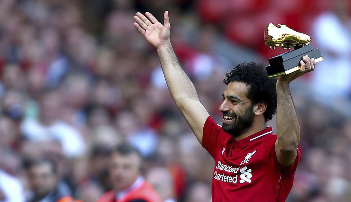 Penyerang Liverpool, Mohamed Salah, mengangkat trofi Sepatu Emas Premier League usai laga melawan Brighton & Hove Albion di Stadion Anfield, Minggu (13/5/2018). Salah menjadi top scorer Premier League dengan raihan 32 gol. (AP/Dave Thompson)