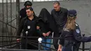 Seorang tersangka dikawal polisi di luar sekolah Vladislav Ribnikar di Beograd, Serbia, Rabu (3/5/2023). Seorang anak laki-laki berusia 13 tahun menembak mati delapan siswa dan seorang penjaga keamanan di sebuah sekolah di Beograd pada Rabu, 3 Mei 2023. (AP Photo)