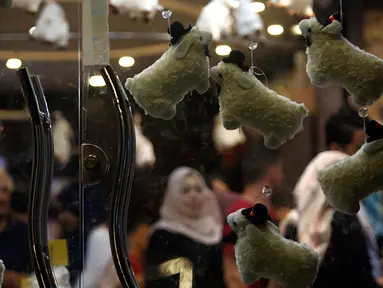 Keluarga Palestina membeli cokelat di sebuah toko yang dihiasi dengan boneka domba menjelang Hari Raya Idul Adha di kota Gaza pada Rabu (29/7/2020). (AP Photo/Hatem Moussa)