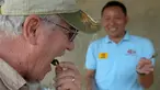 Seorang turis memakan tarantula goreng di wilayah Skun, Provinsi Kampong Cham, Kamboja, 14 Maret 2018. Warga Kamboja terbiasa mengonsumsi tarantula goreng sebagai camilan. (TANG CHHIN Sothy / AFP)