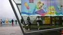 Orang-orang duduk di dalam stan yang dihiasi dengan poster Asian Games 2022 di sepanjang jalur pejalan kaki di sungai Qiantang di Hangzhou, provinsi Zhejiang, China pada 22 September 2023. (MANAN VATSYAYANA/AFP)
