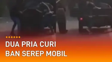 Sebuah rekaman video menunjukkan detik-detik dua pria mencuri ban serep mobil.